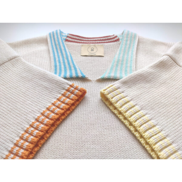 A close up shot of the knit t-shirt ''Simple Pleasures'', focusing on the coloured neck and the arm band parts.