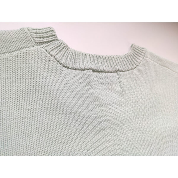 A close up shot of a mint coloured knit t-shirt, showing the nape side of the product.