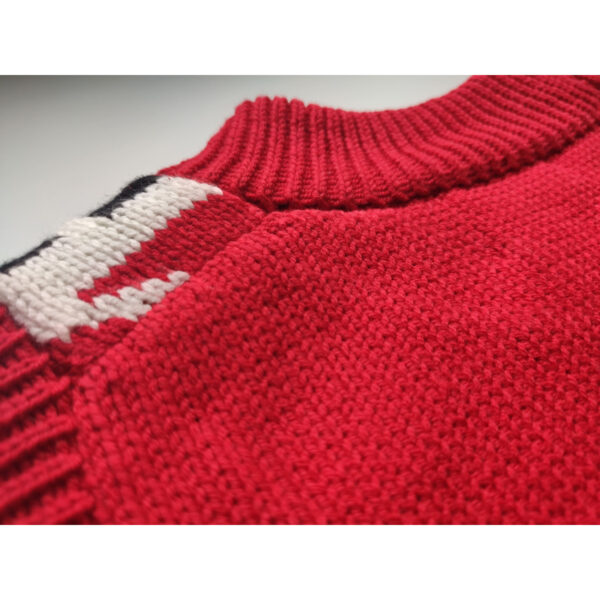 A close up shot of a red coloured fair isle knit vest, showing the nape side of the product.
