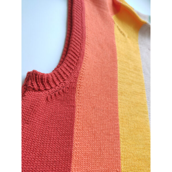 A close up shot of the armhole band of the rainbow coloured knit vest.
