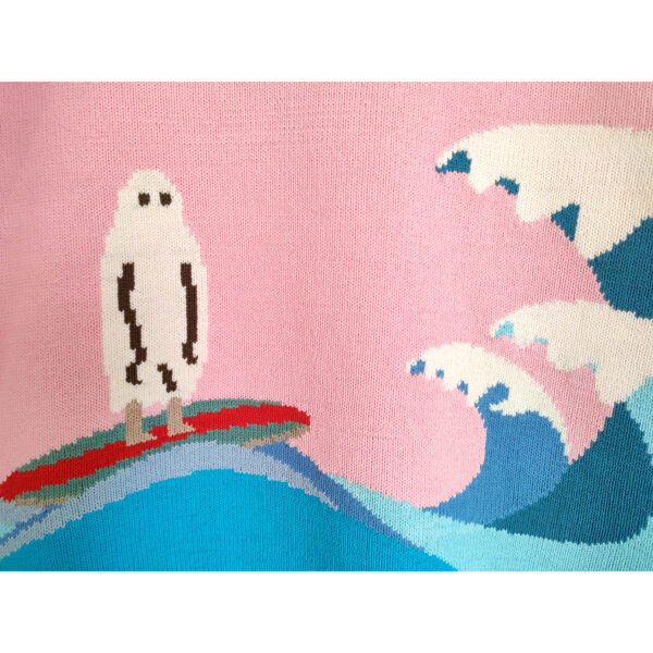 A close up image of a knitted ghost figure surfing on the big waves.