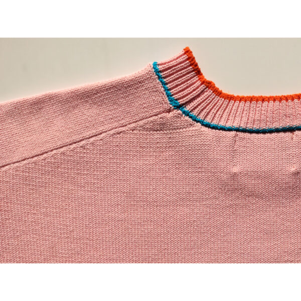 A close up shot of a surfing ghost themed pink knit t-shirt, focusing on the nape and the back.