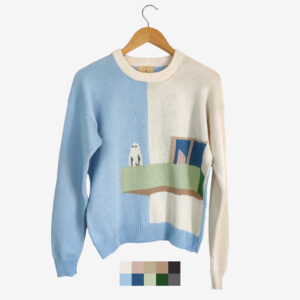 The catalogue shot of an intarsia knit sweater featuring a ghost standing on a balcony, featuring the colours white, blue, grey, green, brown and dark blue.