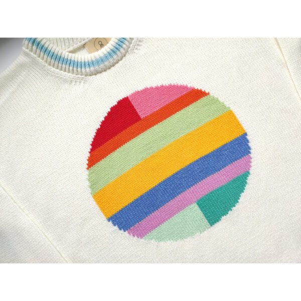 A close up shot of an colourful intarsia sweater, featuring a circle of many colors on the front center.