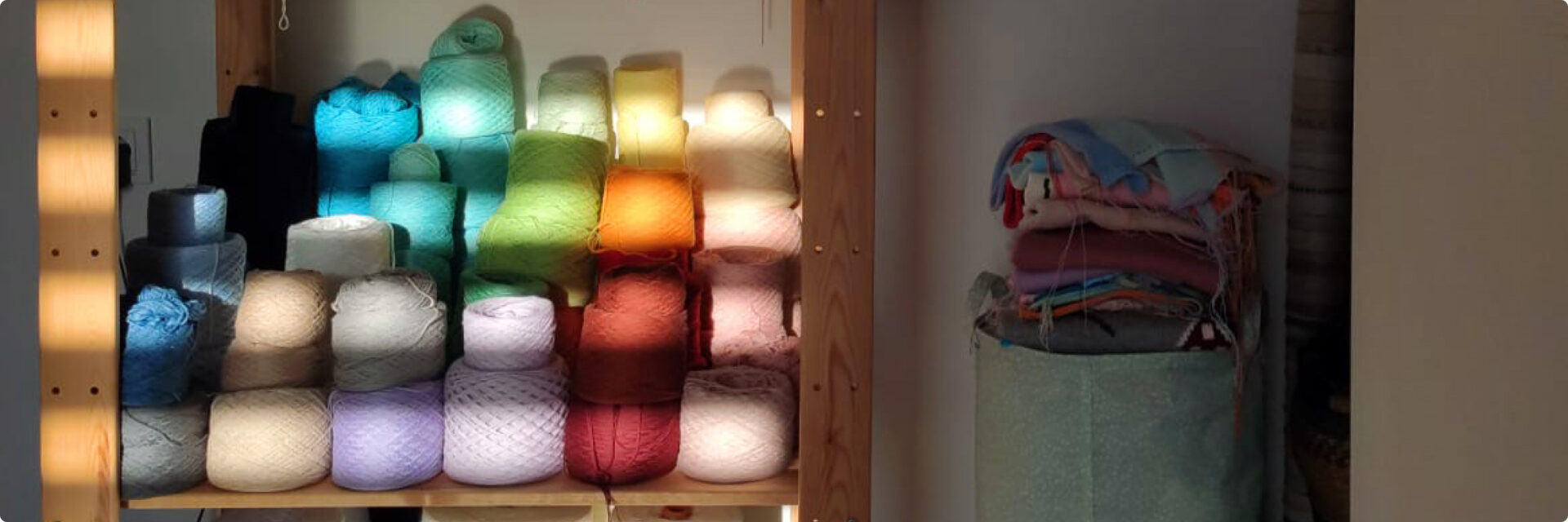 A colourful yarn stock on a shelf, setting sun leaks through the windows and lights the seen.