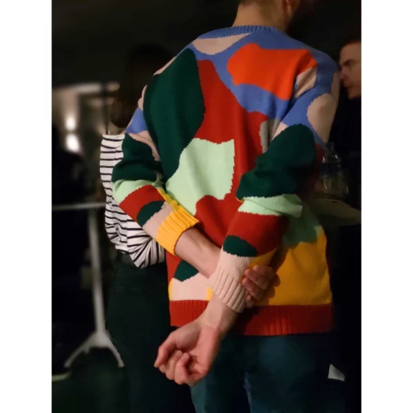A shot of a young man taken from his back, wearing the colourful Collage No.2 sweater.