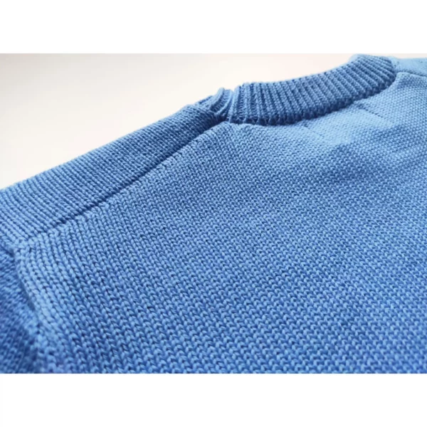 A close up shot of the Cookie-Go-Round sweater by Knyt, focusing on the fine details of the back of the neck band and shoulders.