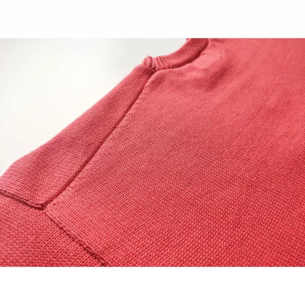 A close up shot of the Reap What You Swing sweater by Knyt, focusing on the fine details of the back of the neck band and shoulders.