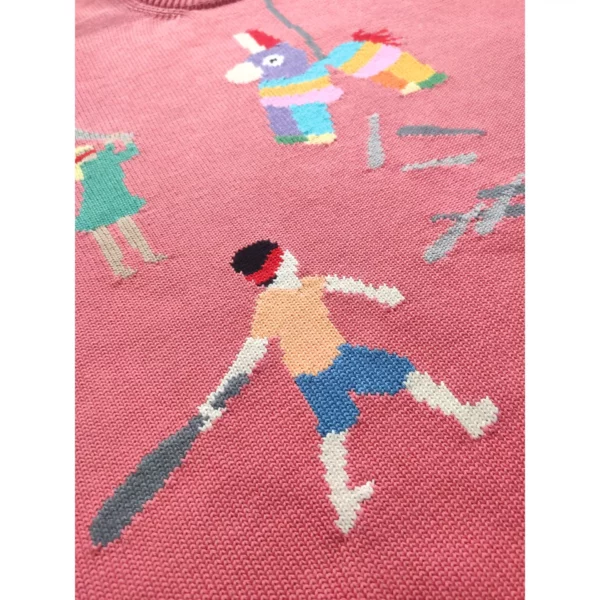 A close up shot of the handmade sweater featuring a couple children wielding baseball bats as they strike a piñata, which, notably, is filled with more baseball bats.