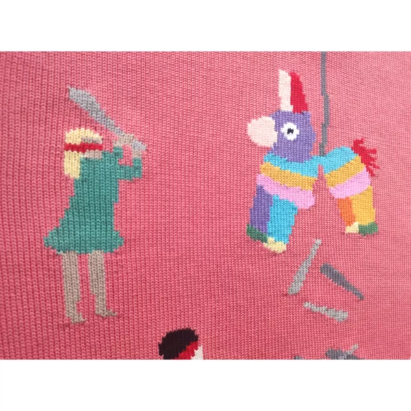 A close up shot of the handmade sweater featuring a kid wielding a baseball bat as she strikes a piñata, which, notably, is filled with more baseball bats.