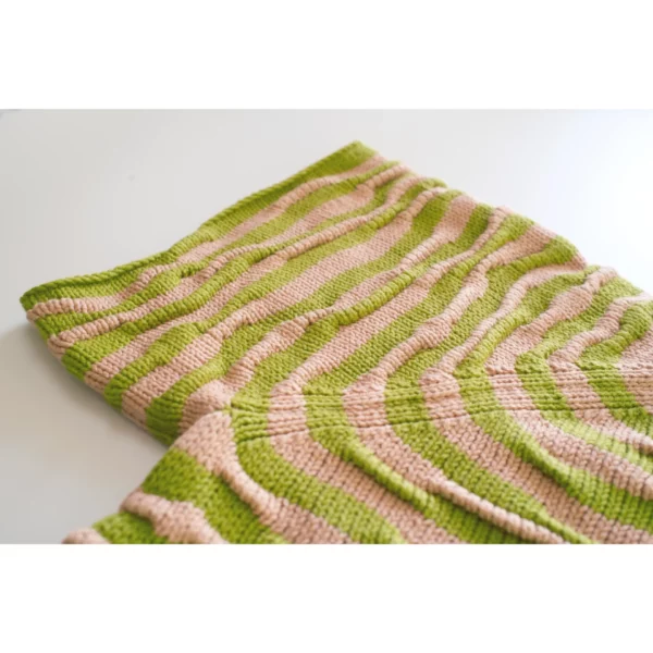A close-up shot of the handmade knit t-shirt Breezer (Caramel), showing the bumpy texture in detail. Warm tones of Soft Caramel and Chartreuse highlight its unique knitting technique, with a focus on the raglan sleeve joins.