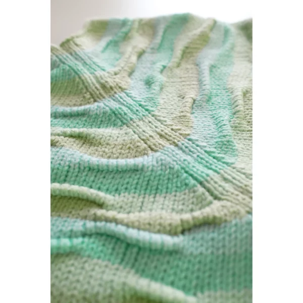 A close-up shot of Breezer (Mint), focusing on the raglan sleeve joins. The bumpy texture and warm tones of Minty Ice Blue and Muted Olive highlight the intricate handmade craftsmanship