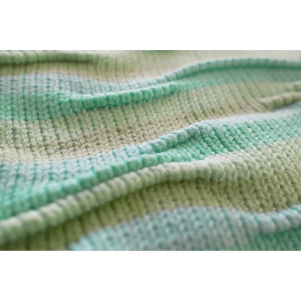 A panoramic shot of Breezer (Mint), focusing on the wavy bumpy texture. The handmade knit t-shirt’s unique design and warm tones of Minty Ice Blue and Muted Olive are beautifully highlighted in this wide-angle view.