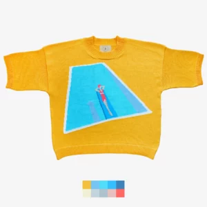 Catalogue photo of the intarsia knit t-shirt Chlorine v2 by Knyt, featuring a woman laying on a springboard at the swimming pool. Featuring yellow, blue, dark blue, red and rose colours.